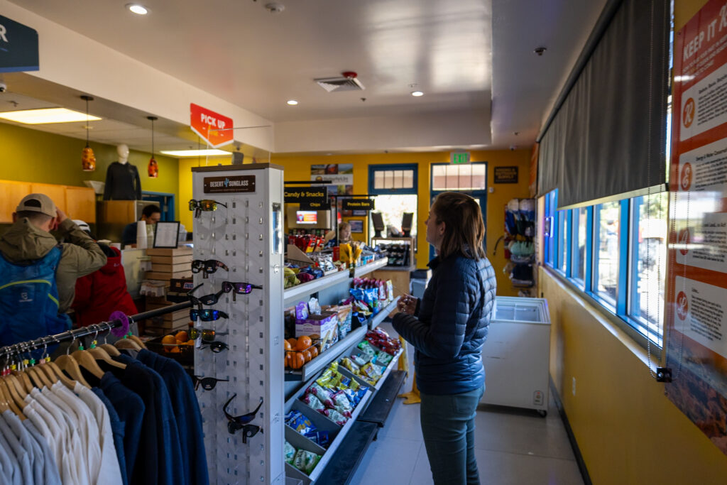 Jen looking at the menu inside Canyon Adventures Bike Tours & Café, a deli-style eatery at Grand Canyon South Rim
