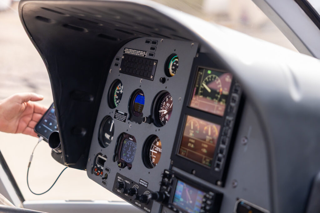 Helicopter cockpit instrument panel with gauges, dials, and screens visible during pre-flight checks