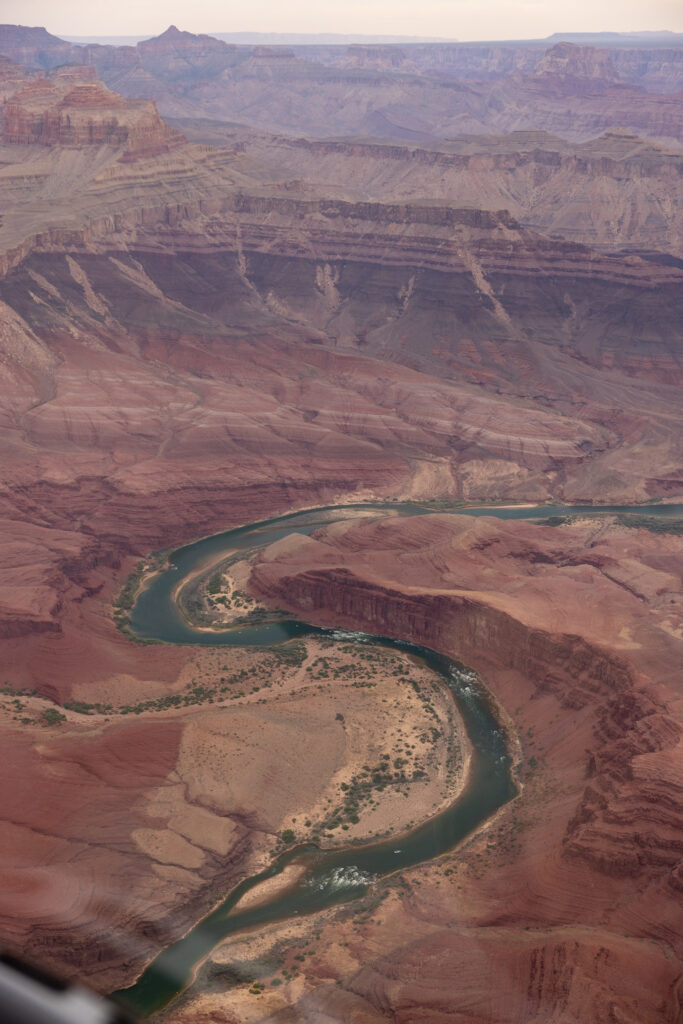 An oxbow in the Colorado River in the Grand Canyon, viewed from a helicopter, showing the turquoise water making a sharp U-turn through red rock formations