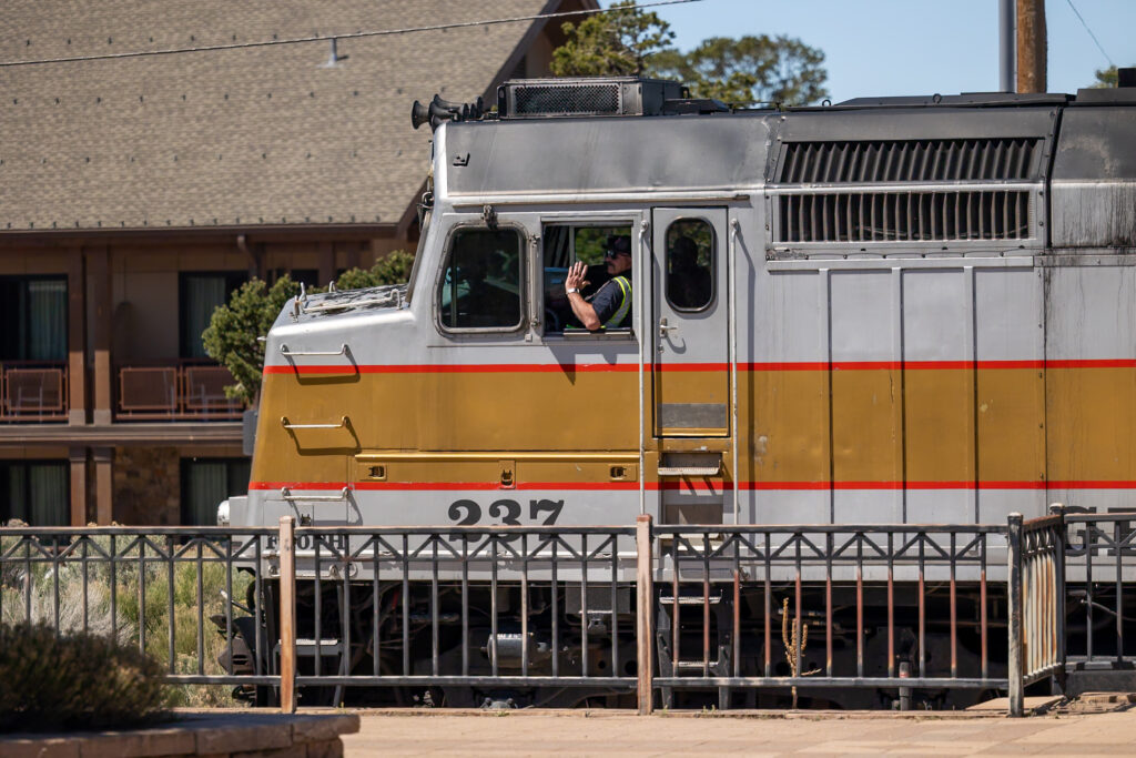 Grand Canyon Railway locomotive number 237 with operator waving from the cab window