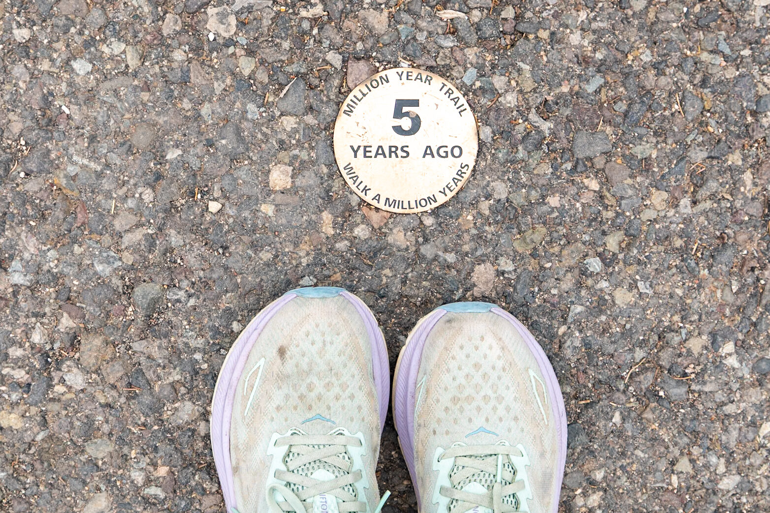 Time plaque on the Trail of Time marking 5 million years of geological history, with Jen's shoes visible below it