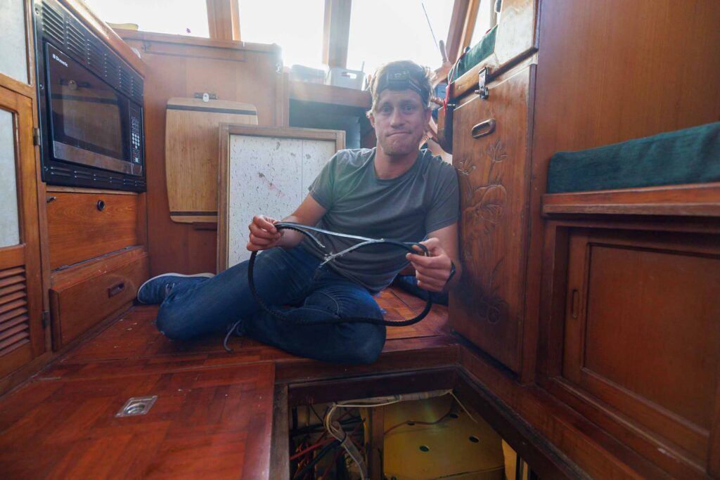 Elliot sitting in front of the engine room with a broken belt