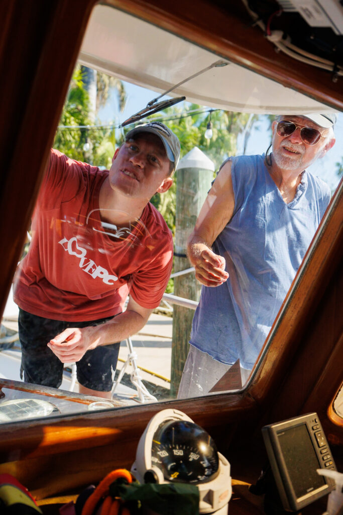 Keeping up with boat maintenance as Elliot and our friend Bill re-caulk our front windows after finding a small leak.