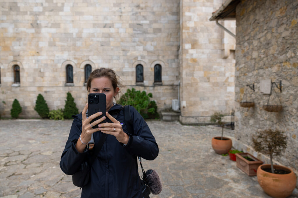 Jen in front of castle holding cell phone