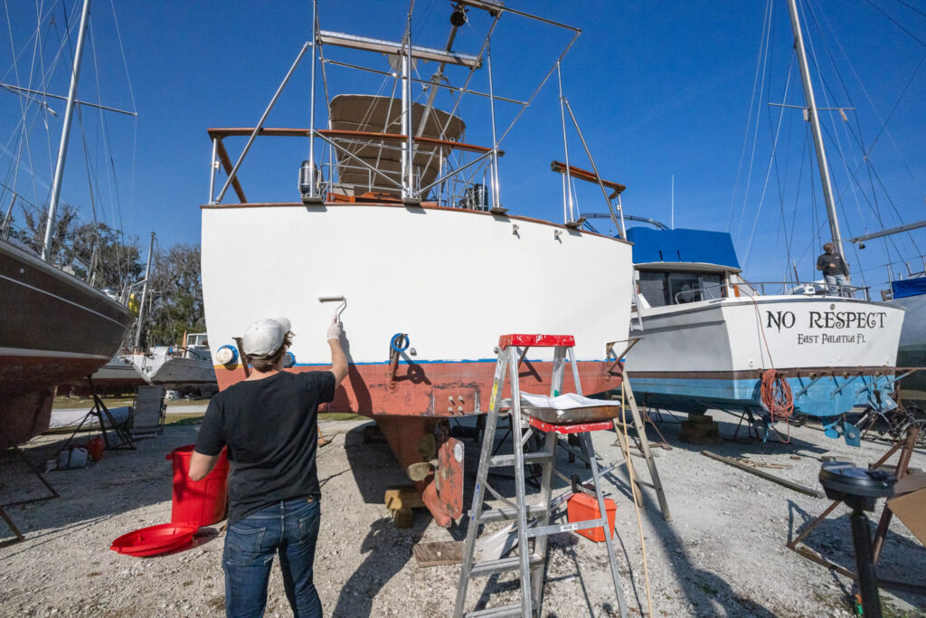 Elliott painting the boat they live on