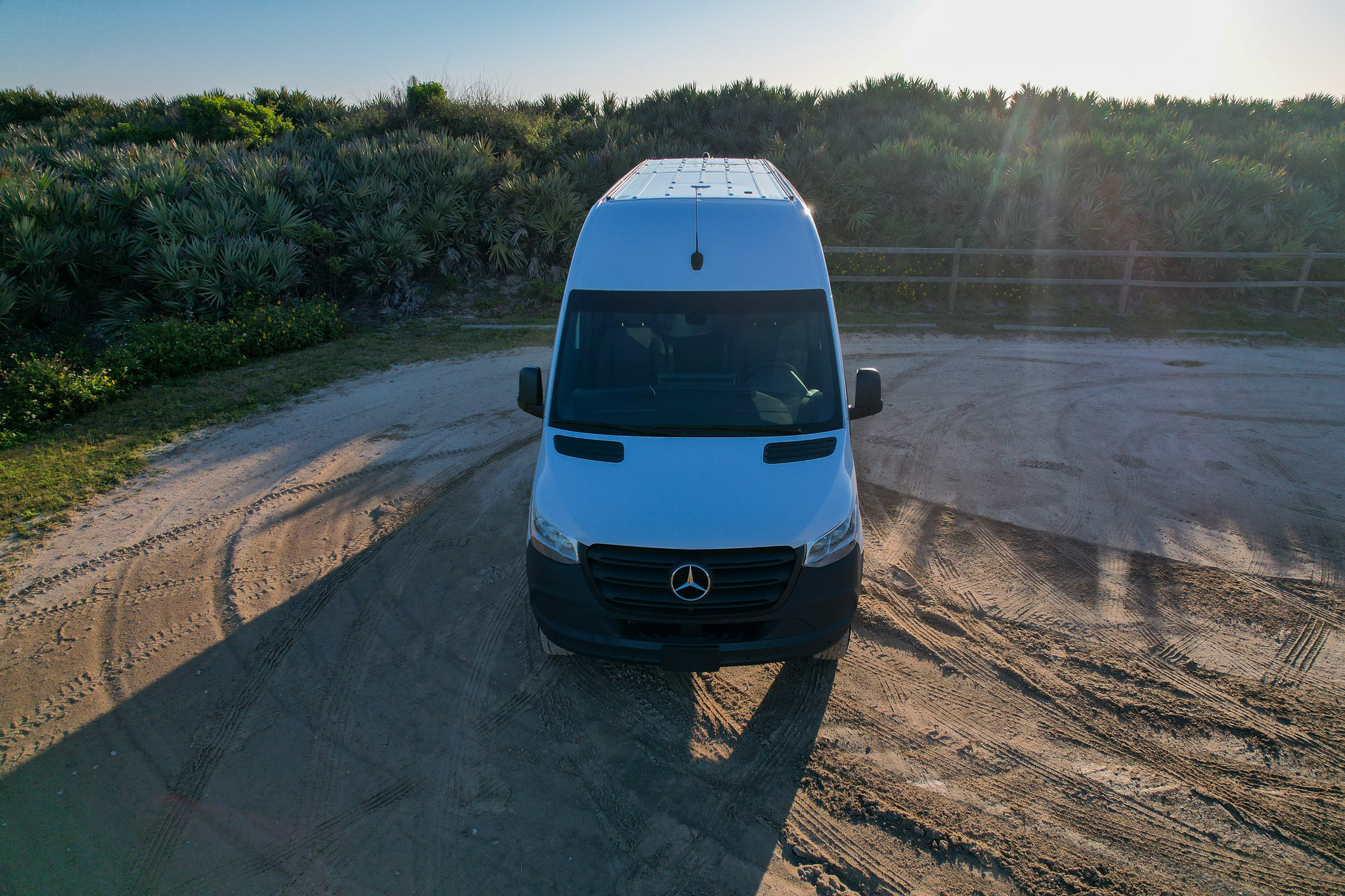 mercedes van on beach drone shot forward facing