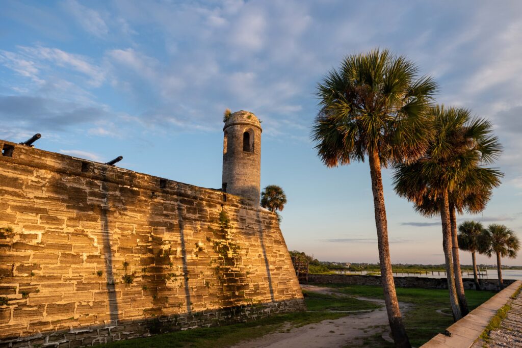 Stone fort with watchtower and palm trees at sunset, Castillo de San Marcos in St. Augustine, Florida